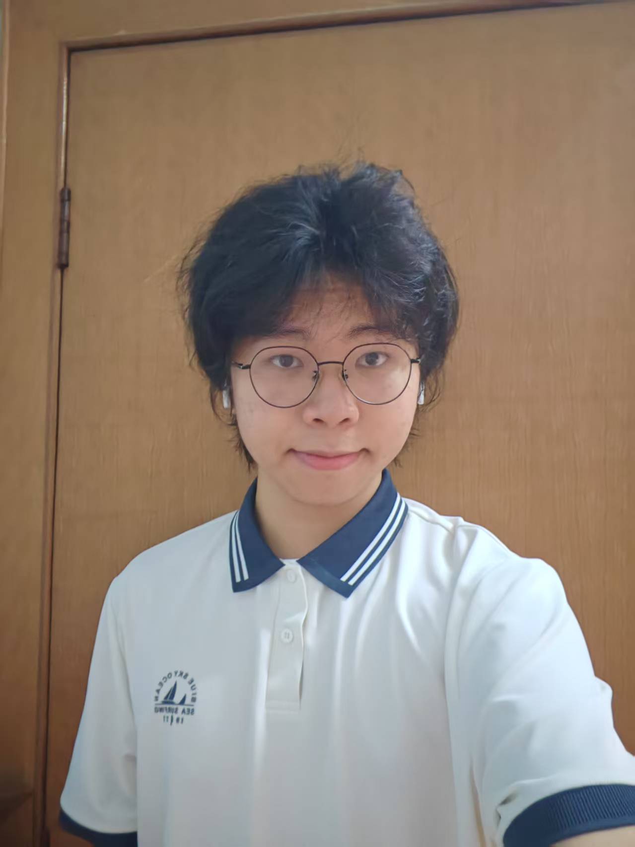 罗子秋的日常自拍，戴圆框眼镜、耳机和白色 Polo 衫